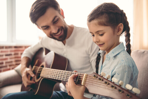 Pai tocando violão com a filha
