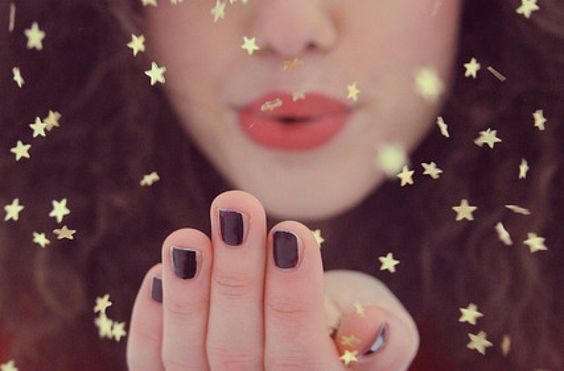 Mulher soprando estrelas douradas