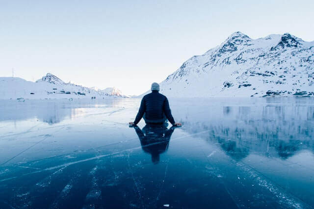 Homem sentado em lago congelado