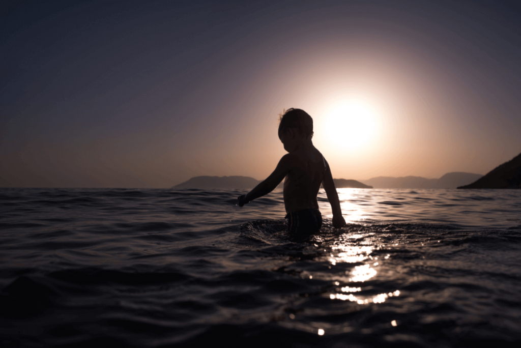 Criança brincando no mar