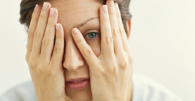 Mulher cobrindo um olho e deixando o outro aberto