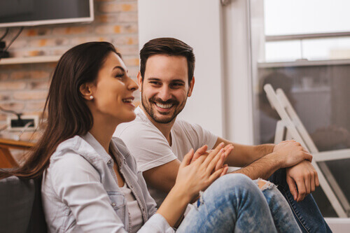 Casal conversando e sorrindo em casa