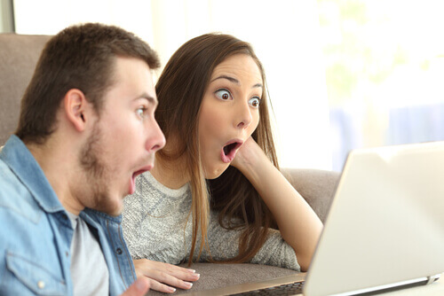 Casal surpreso olhando o computador