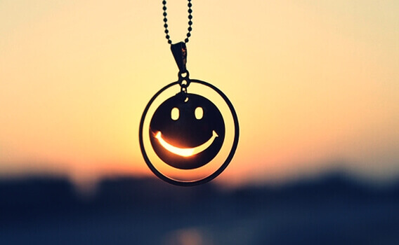 Pingente de emoji diante do por do sol