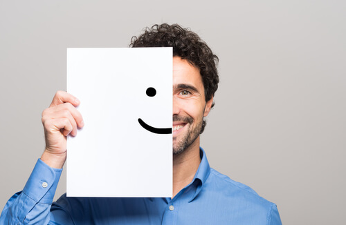 Homem com sorriso desenhado em folha de papel