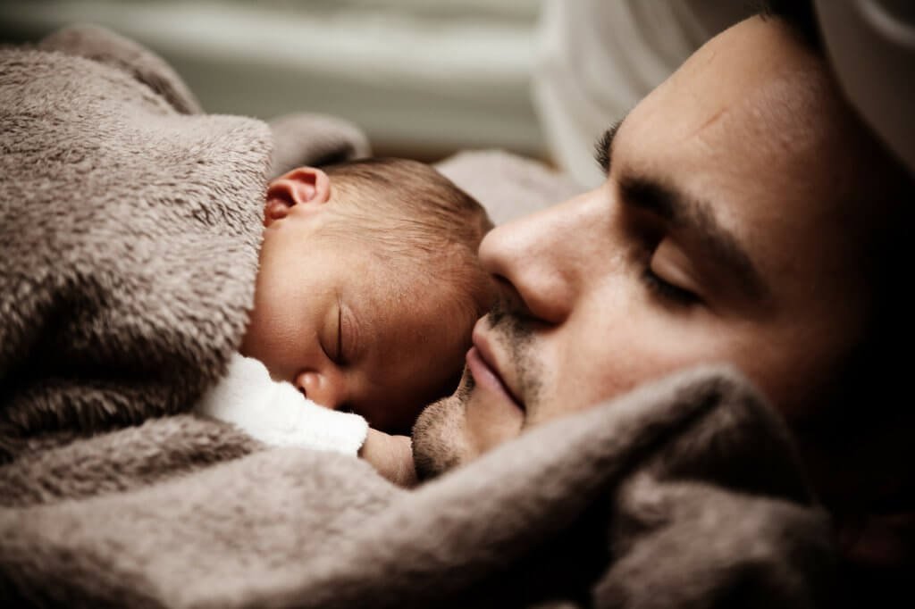 Pai dormindo com seu bebê