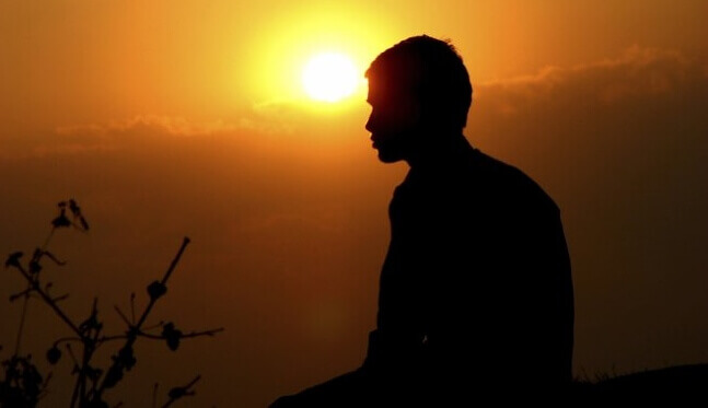 Perfil de homem diante do sol