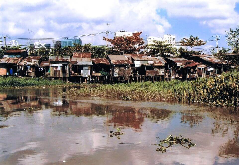 Bairro pobre diante de córrego