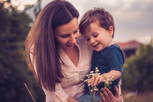 Mãe pegando flores com seu filho no colo