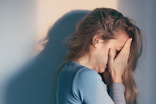 Mulher chorando com as mãos no rosto