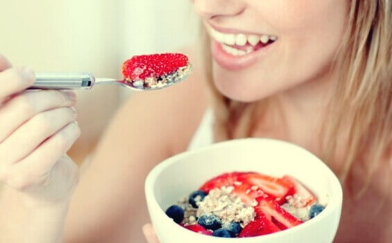 Mulher comendo aveia com frutas