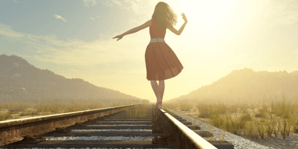Mulher andando em trilho de trem