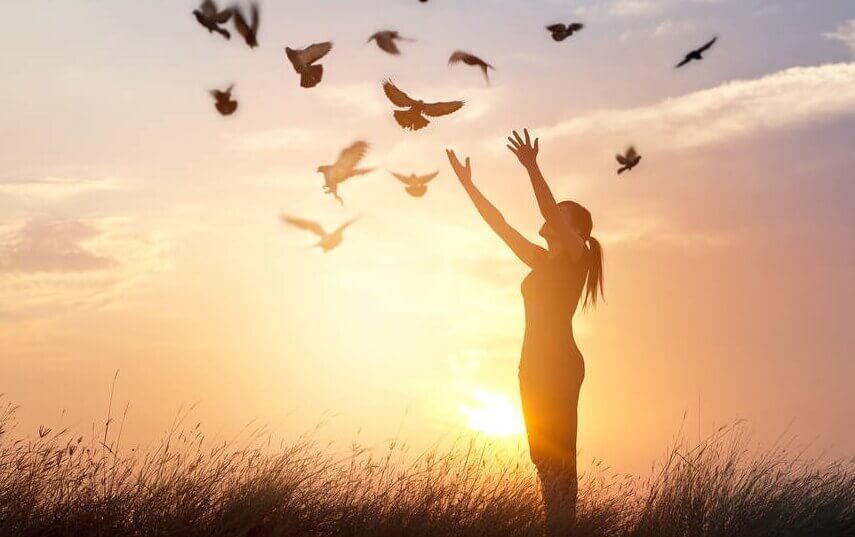 Mulher com pássaros voando ao seu redor