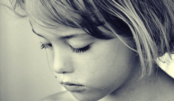 Menina triste com o olhar baixo