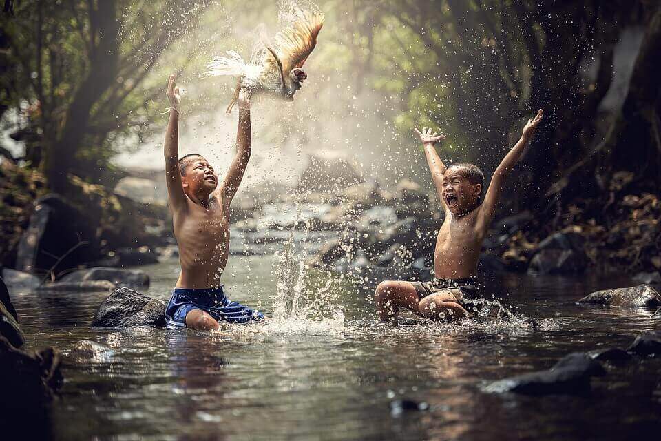 Crianças asiáticas brincando em rio