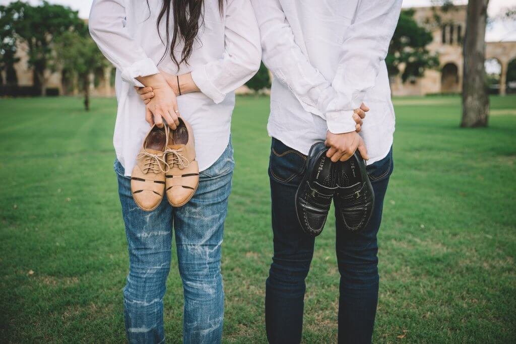 Homem e mulher segurando seus sapatos