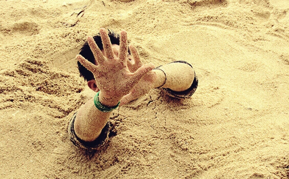 Homem enterrado na areia