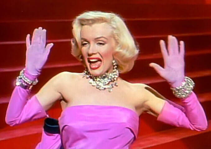 Marilyn Monroe usando vestido e luvas cor-de-rosa