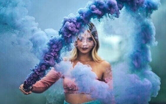 Mulher com fumaça colorida