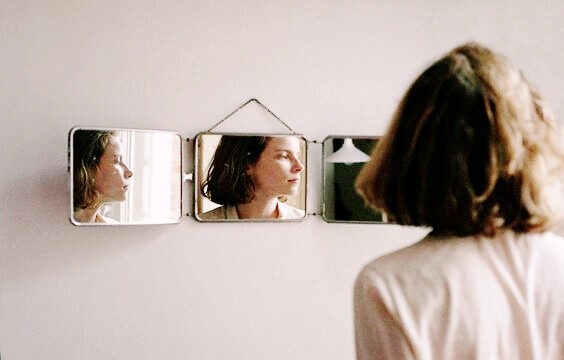 Mulher se olhando em espelhos