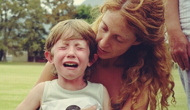 Mãe tentando acalmar filho chorando