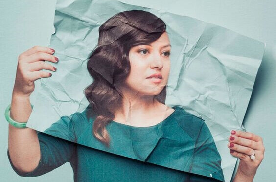 Mulher com uma foto sua diante do rosto