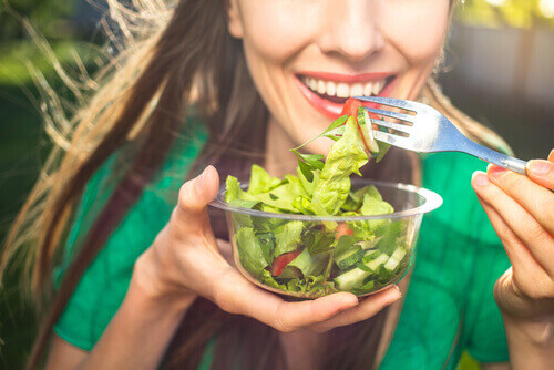Mulher comendo salada