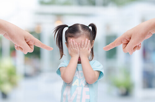 Pais apontando o dedo para filha pequena