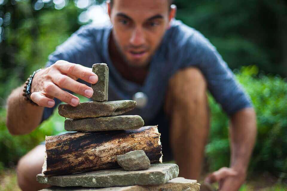 Homem empilhando pedras