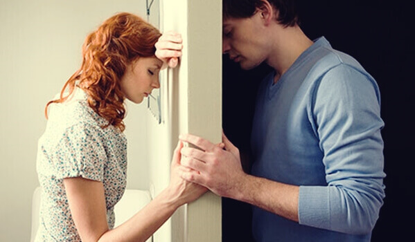 Mulher e homem separados por porta