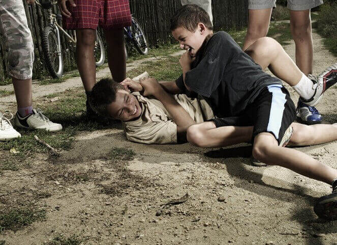 Crianças brigando com outras assistindo