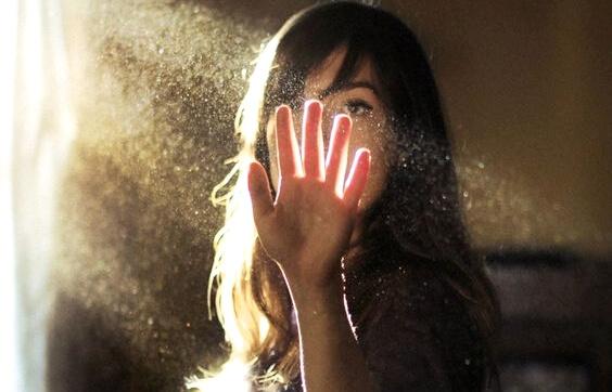 Mulher colocando a mão em feixe de luz