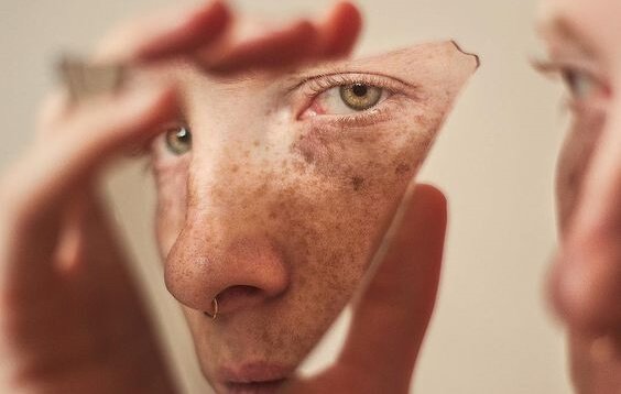 Rosto no espelho quebrado