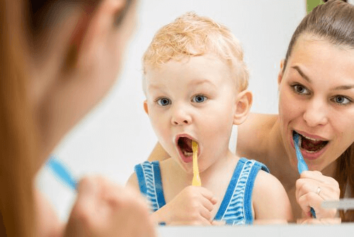 Mãe e filho escovando os dentes