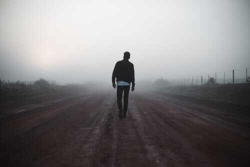 Homem em estrada com neblina