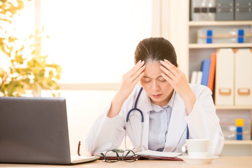 Médica cansada no consultório