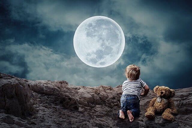 Menino pequeno diante da lua cheia