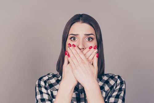 Mulher cobrindo sua boca