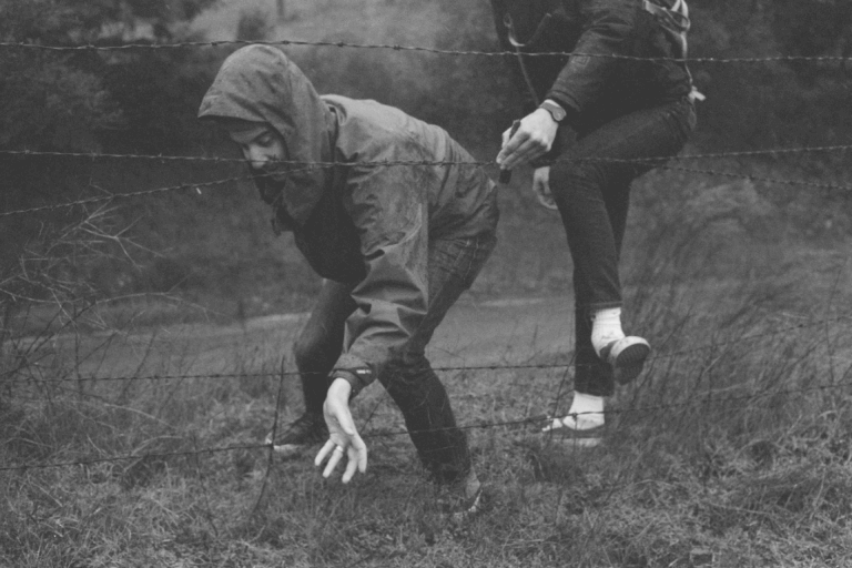 Pessoas cruzando cerca