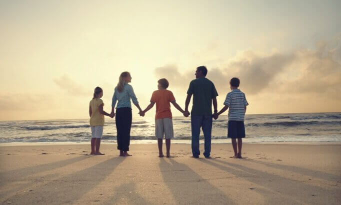 Família de mãos dadas na praia