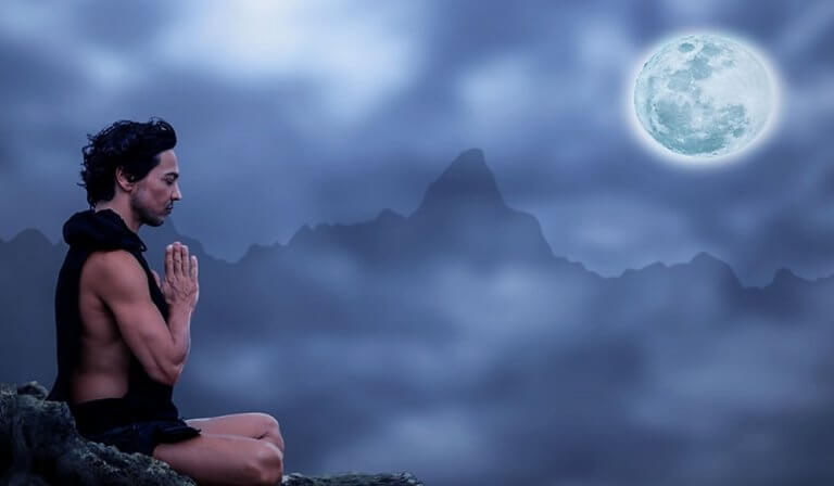 Homem meditando sob a luz do luar