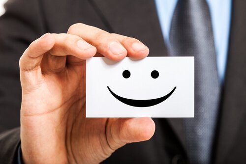 homem-mostrando-cartaz-sorridente Ser feliz no trabalho