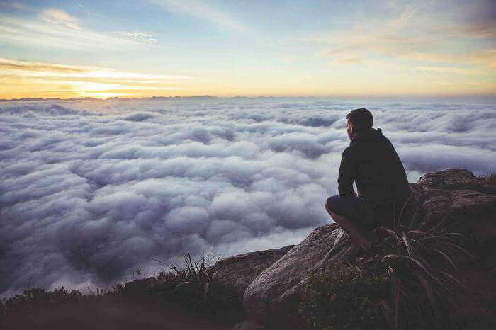 Homem observando colchão de nuvens