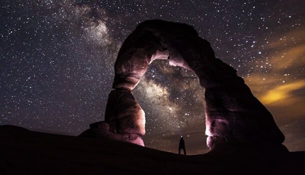 Homem em paisagem sob céu estrelado