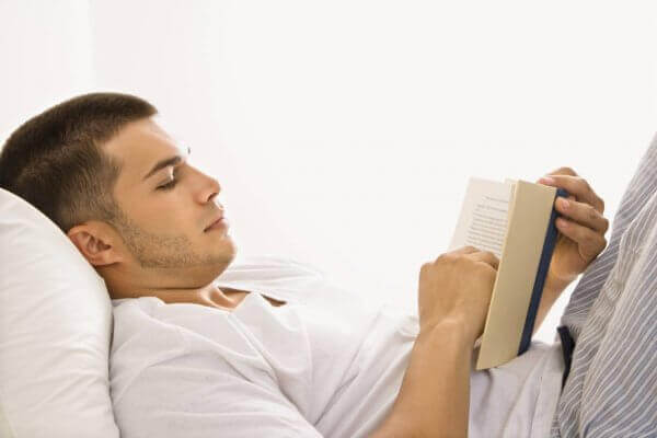 Homem lendo em sua cama