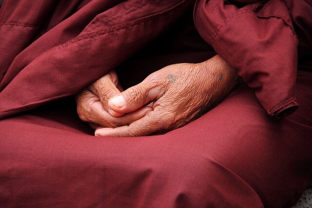 Mãos de monge idoso