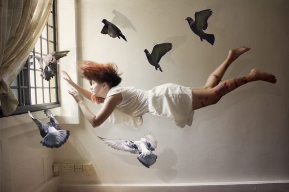 Mulher flutuando com pombos