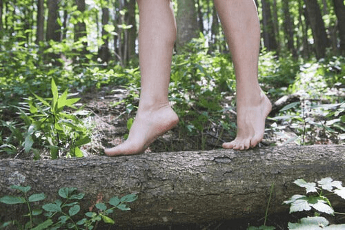 Pessoa passeando descalça em floresta