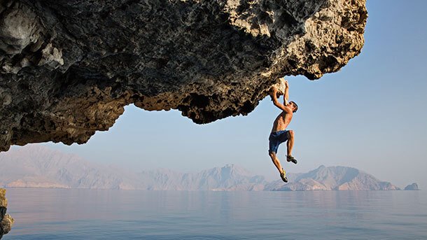 Homem fazendo escalada arriscada