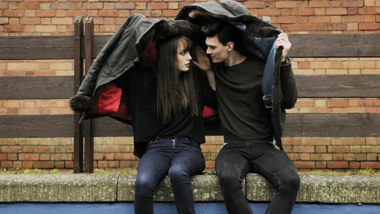 Casal se protegendo da chuva